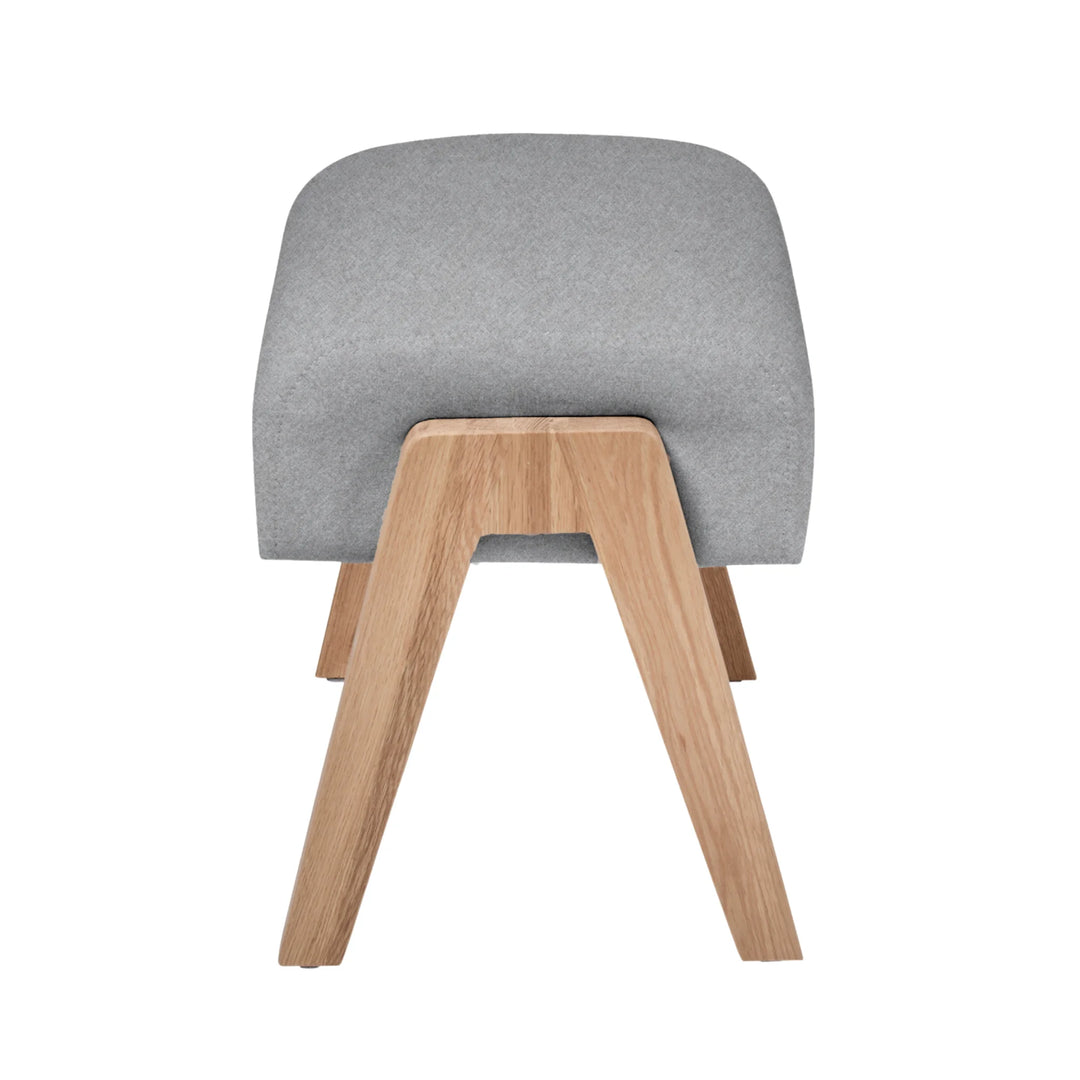 Hera footstool dusk side shot with oak wood grain legs.