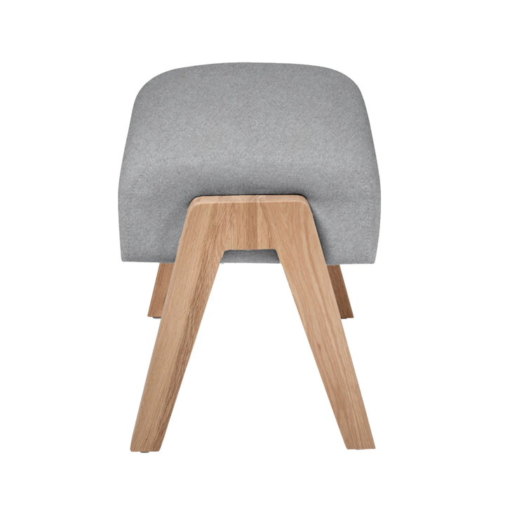 Hera footstool dusk side shot with oak wood grain legs.