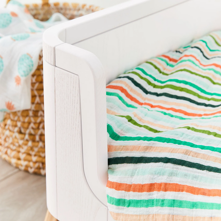 Lifestyle image detail of the corner of the Hera Cot Bed wood grain