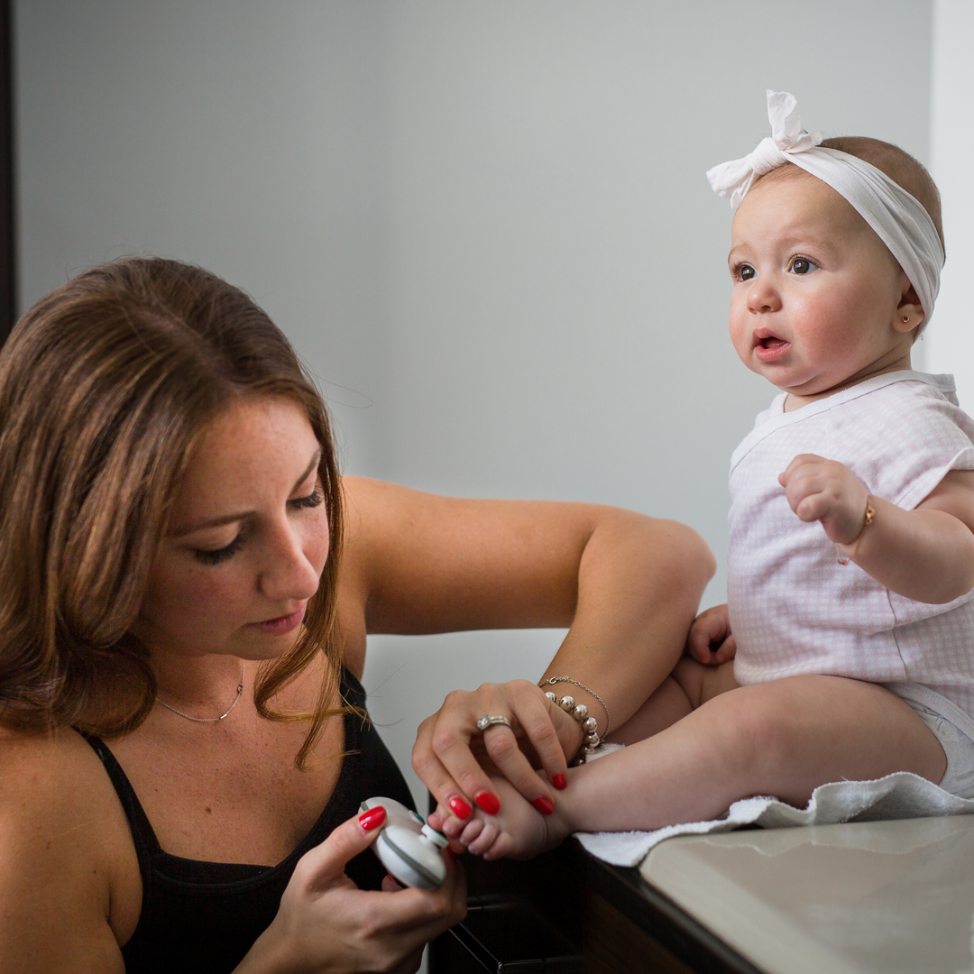 The BBLuv Trimo nail trimmer being used by a mother to file her child's toenails.