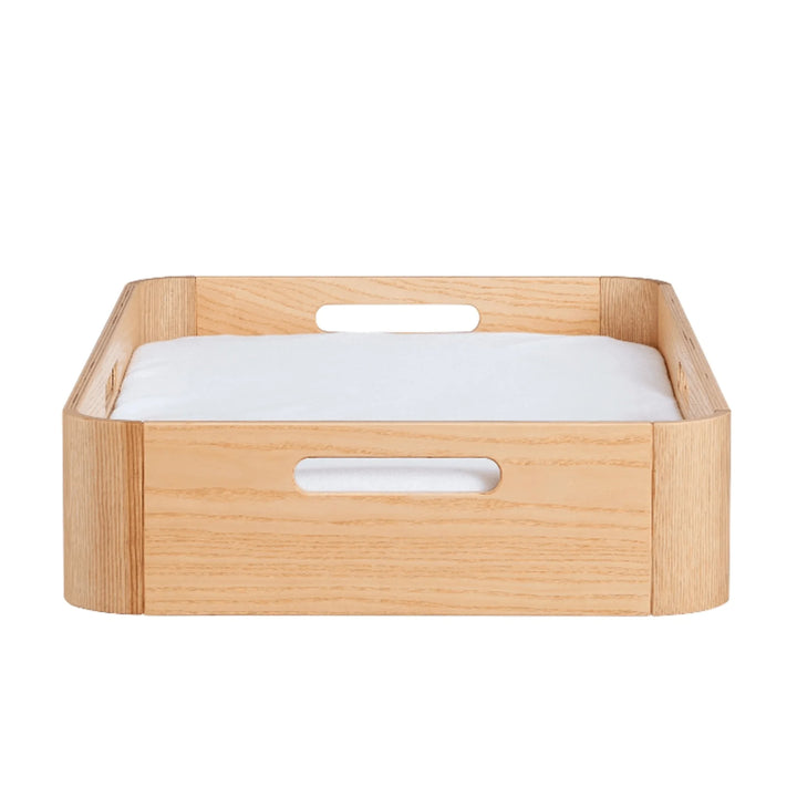 Gaia Baby Hera natural wood changing station with raised sides and integrated carry handles, shown with padded changing mat for modern nursery furniture setup.