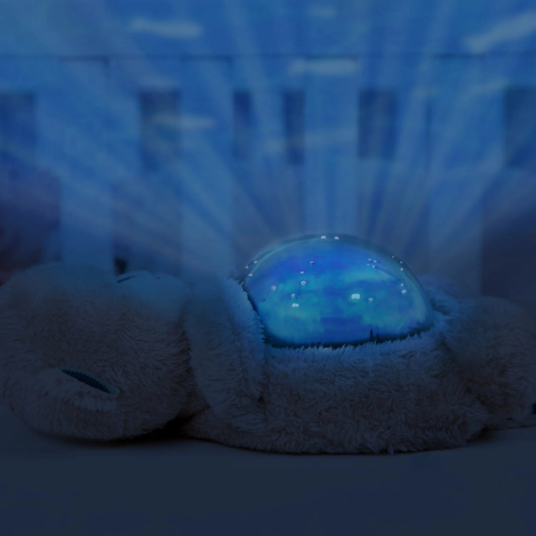 ZAZU Otto the Otter ocean projector night light glowing blue in a dark nursery.