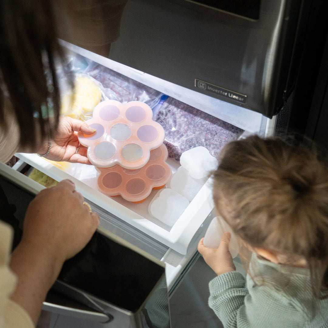 Parent placing Chiill by Quark silicone baby food freezer tray in freezer – BPA-free 7-portion container for storing homemade baby food, purees, or breast milk.
