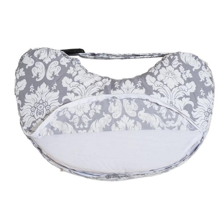 Bebe au Lait Complete Nursing Pillow in Chateau Silver, shown from the underside with the grey and white damask cover partially unzipped to reveal the removable, washable insert and ergonomic C-shaped support design for breastfeeding and bottle feeding.
