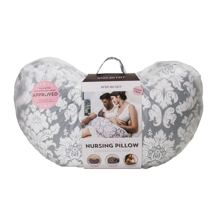 Bebe au Lait Complete Nursing Pillow in Chateau Silver design, shown in packaging with grey and white damask print, foam-free fill, lactation consultant approved badge, and imagery of parents using the ergonomic breastfeeding support pillow.