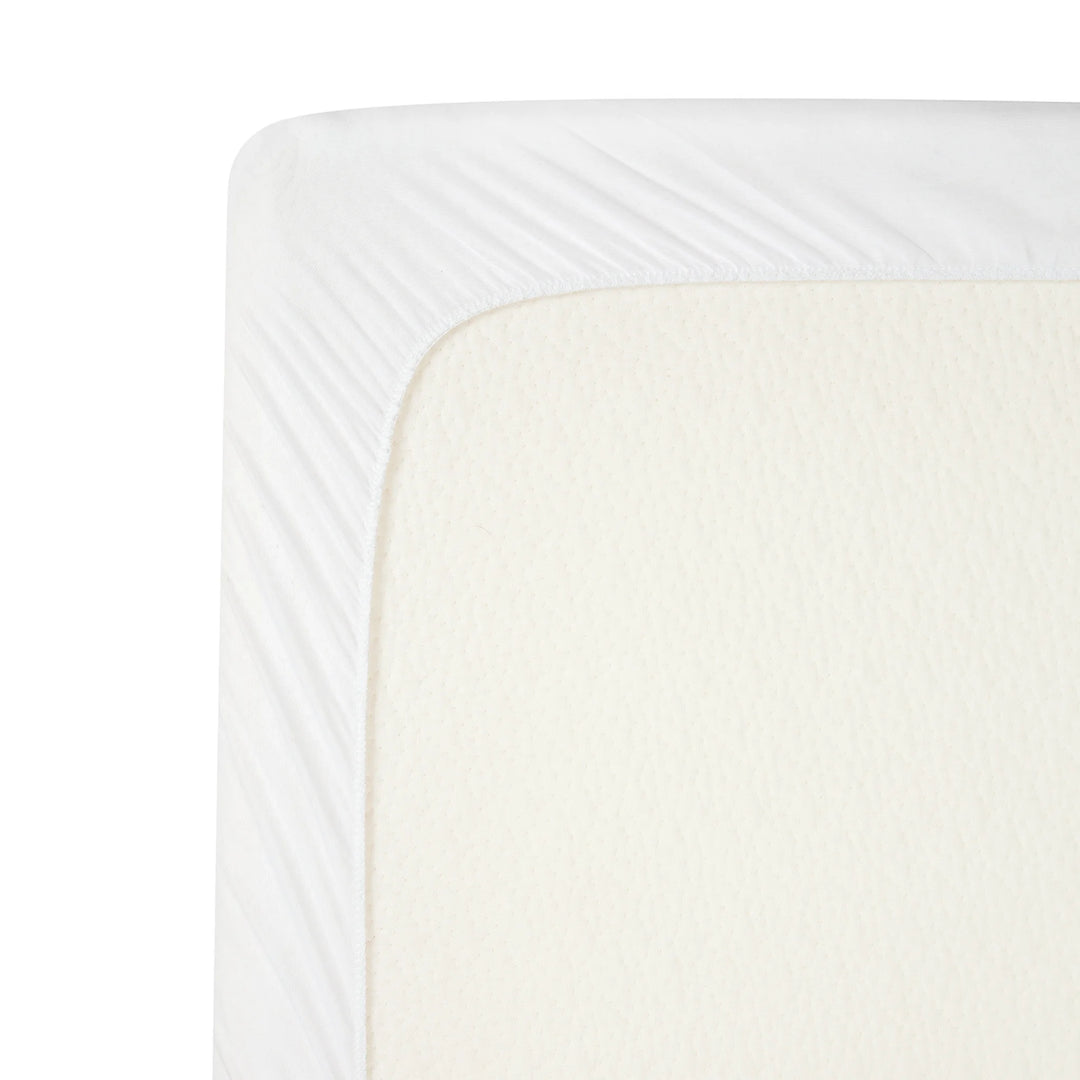 Close-up of the ClevaMama brushed cotton waterproof mattress protector fitted securely over a baby mattress, showing soft breathable fabric and elasticated corner for a snug fit.