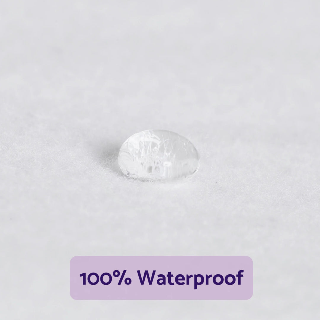 Close-up of a water droplet resting on the ClevaMama brushed cotton waterproof mattress protector surface, demonstrating 100% waterproof protection for baby mattresses.