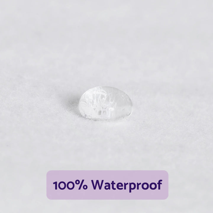Close-up of a water droplet resting on the ClevaMama brushed cotton waterproof mattress protector surface, demonstrating 100% waterproof protection for baby mattresses.
