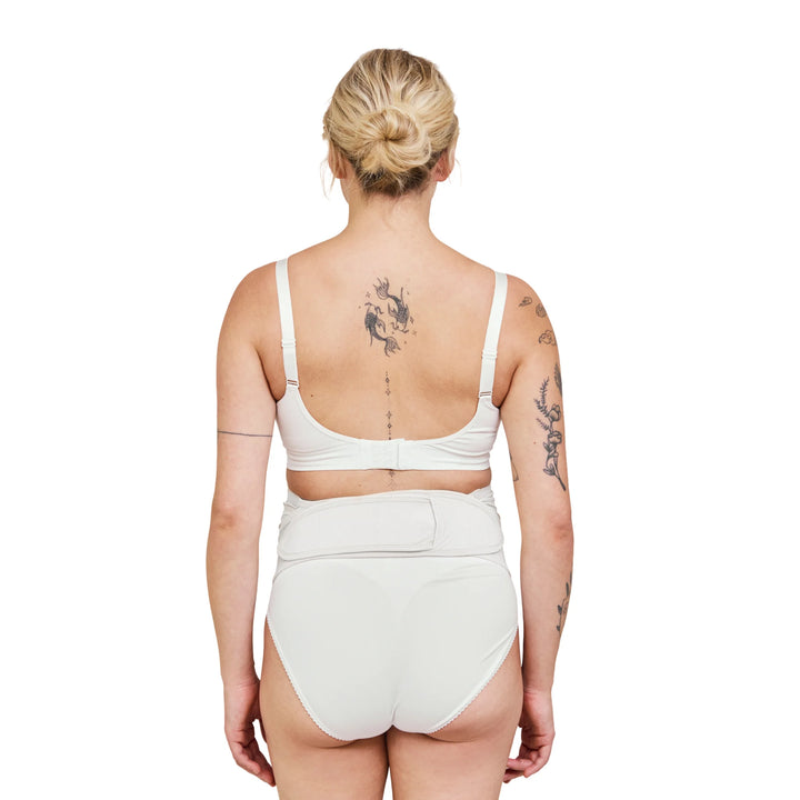 Back view of Carriwell adjustable maternity support belt in white worn by pregnant model, showing secure fit and supportive design for pregnancy belly and lower back support.
