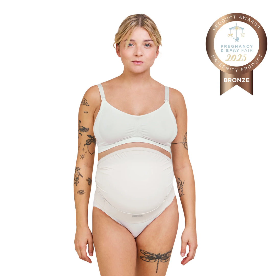 Carriwell adjustable maternity support belt in white worn by pregnant model, providing comfortable bump and back support during pregnancy, award-winning maternity belly support belt for everyday wear.