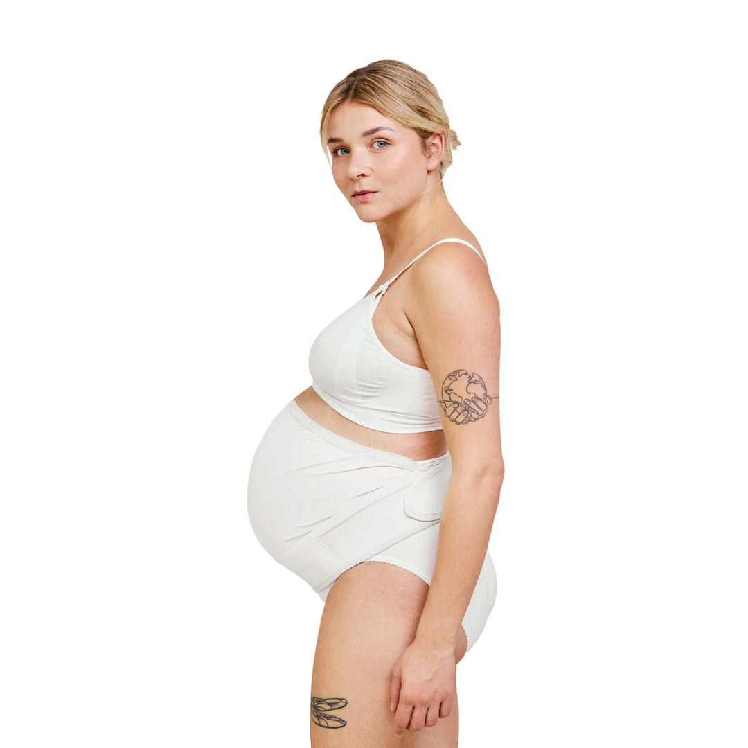 Carriwell adjustable maternity support belt in white shown from side view on pregnant model, offering gentle belly lift and lower back support during pregnancy, comfortable adjustable maternity belly band.