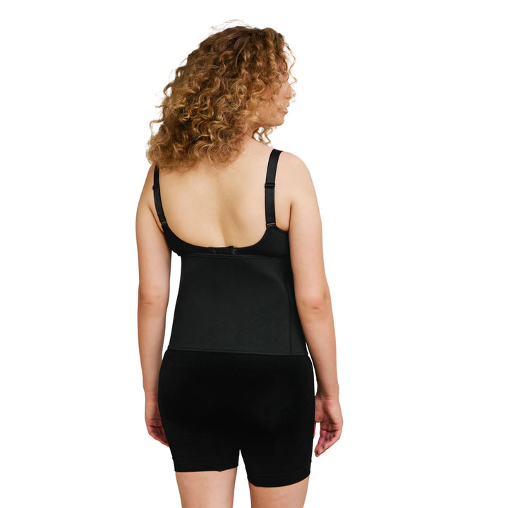 Woman wearing a black post-birth compression garment on a white background