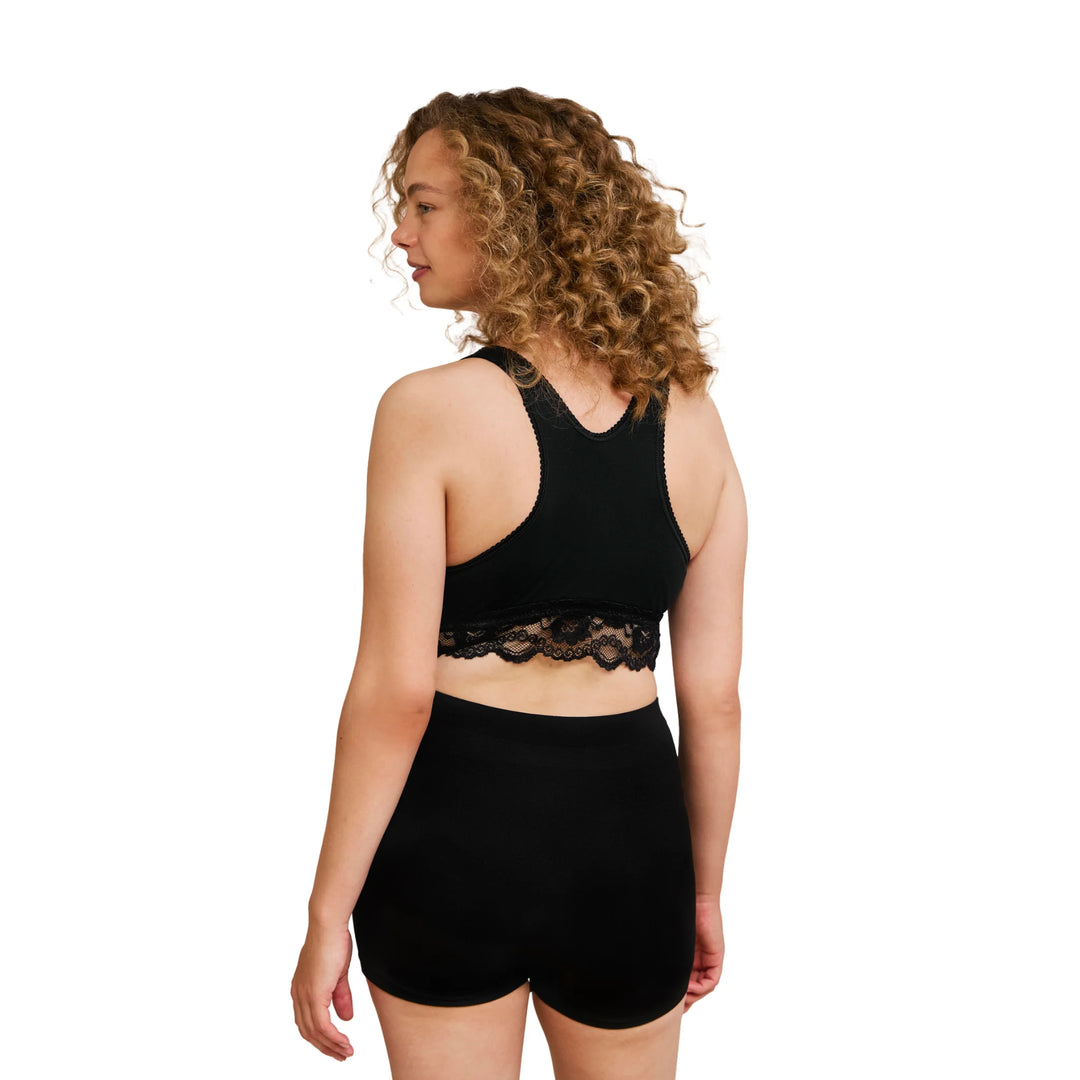 Back view of woman wearing a black Carriwell crossover sleeping and nursing bra with racerback design and lace underband, offering comfortable support for pregnancy and breastfeeding.