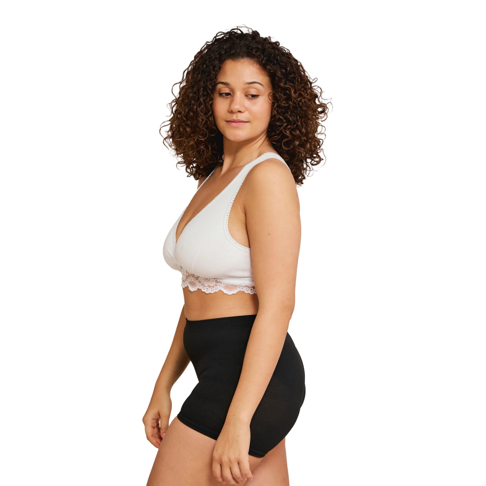 Side view of woman wearing a white Carriwell crossover sleeping and nursing bra with lace trim, designed for comfortable support and easy breastfeeding during pregnancy and postpartum.