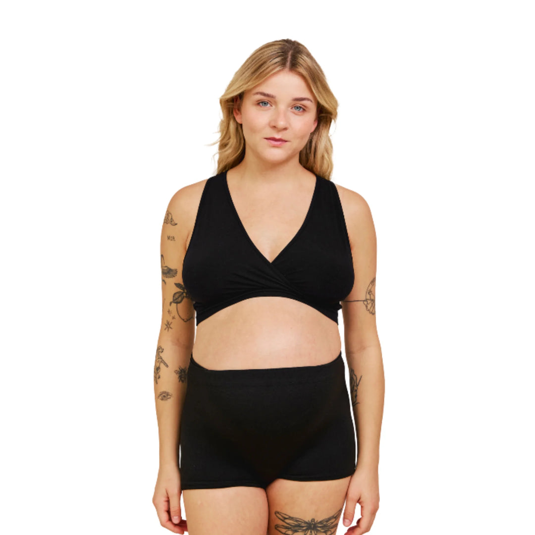 Front view of a pregnant woman wearing Carriwell maternity hospital pants in black, featuring a soft, breathable, seamless design for comfort during labour, hospital stays and postnatal recovery.