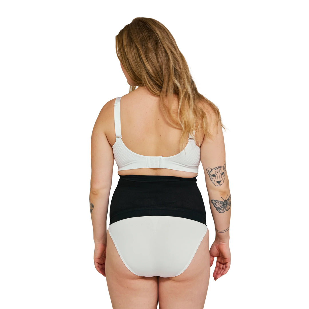Back view of pregnant woman wearing a black Carriwell maternity support band, designed to provide comfortable lower back and abdominal support throughout pregnancy.