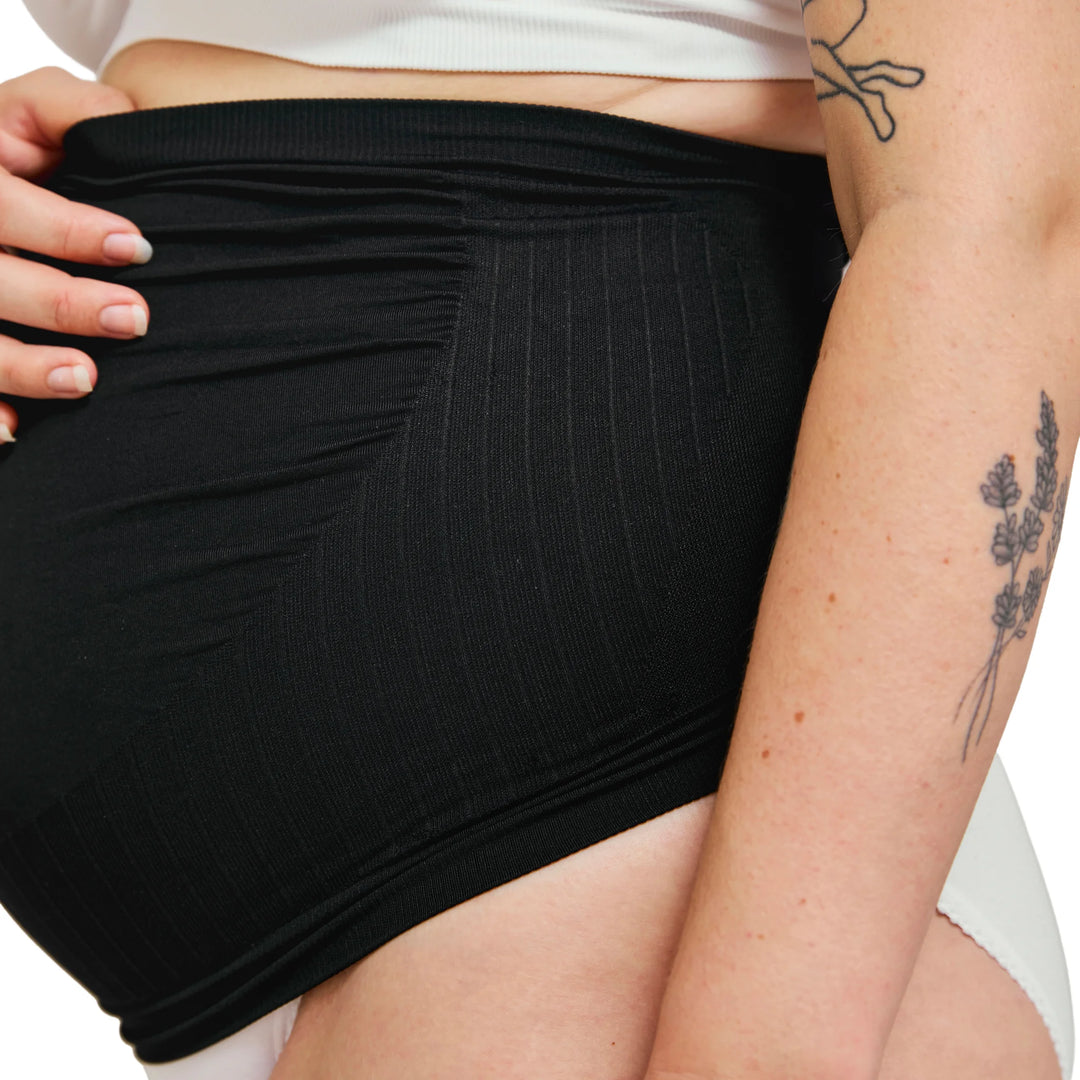 Close-up of black Carriwell maternity support band showing soft stretch fabric and seamless over-bump design for gentle belly and lower back support during pregnancy.