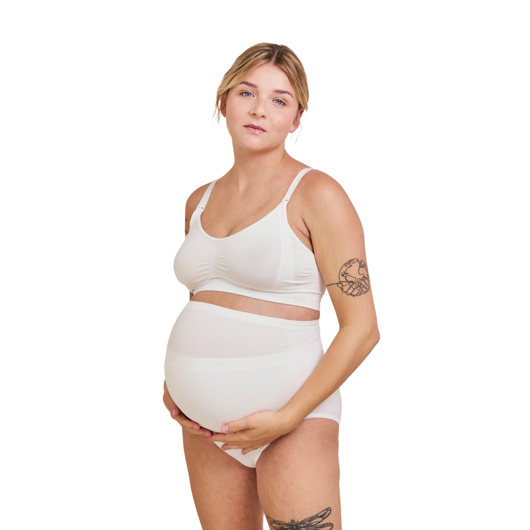 Front view of pregnant woman wearing white Carriwell maternity support band, designed to provide gentle over-bump and lower back support for comfort throughout pregnancy.