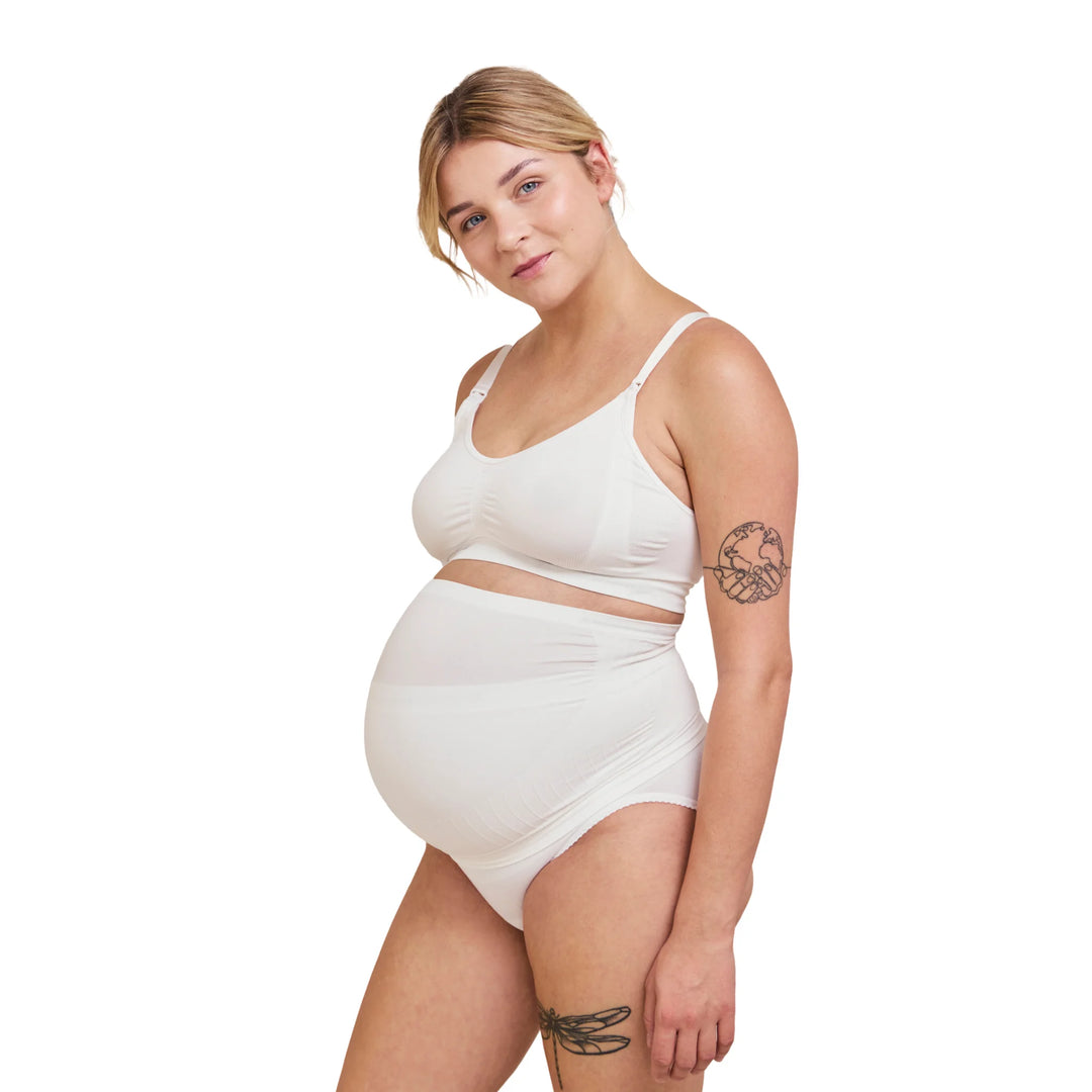 Side view of pregnant woman wearing white Carriwell maternity support band, providing gentle over-bump and lower back support for comfort throughout pregnancy.