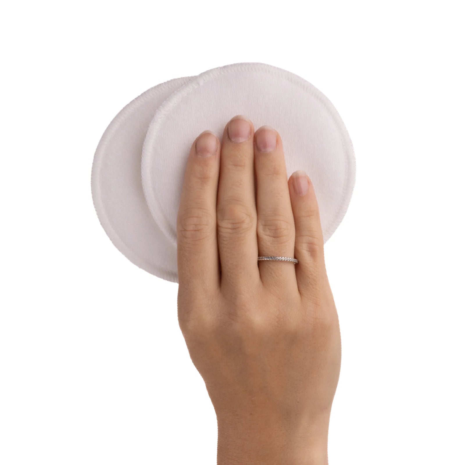 Hand holding two carriwell reusable breast pads