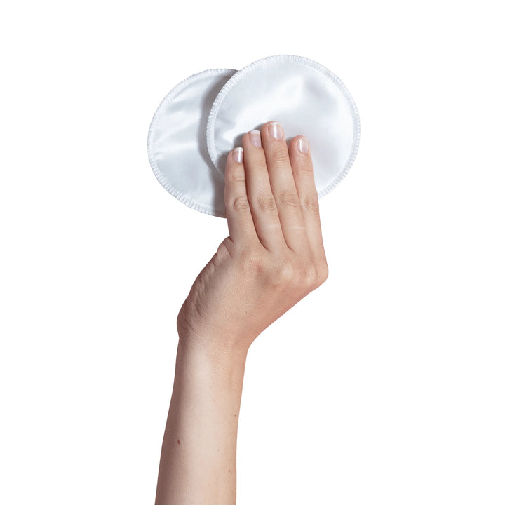 hand holding Carriwell silk reusable breast pads