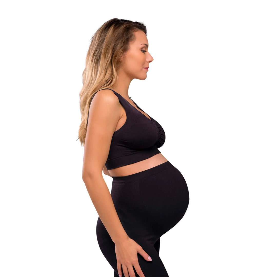 Side view of pregnant woman wearing a black Carriwell seamless maternity bra, offering stretch support and comfort throughout pregnancy.