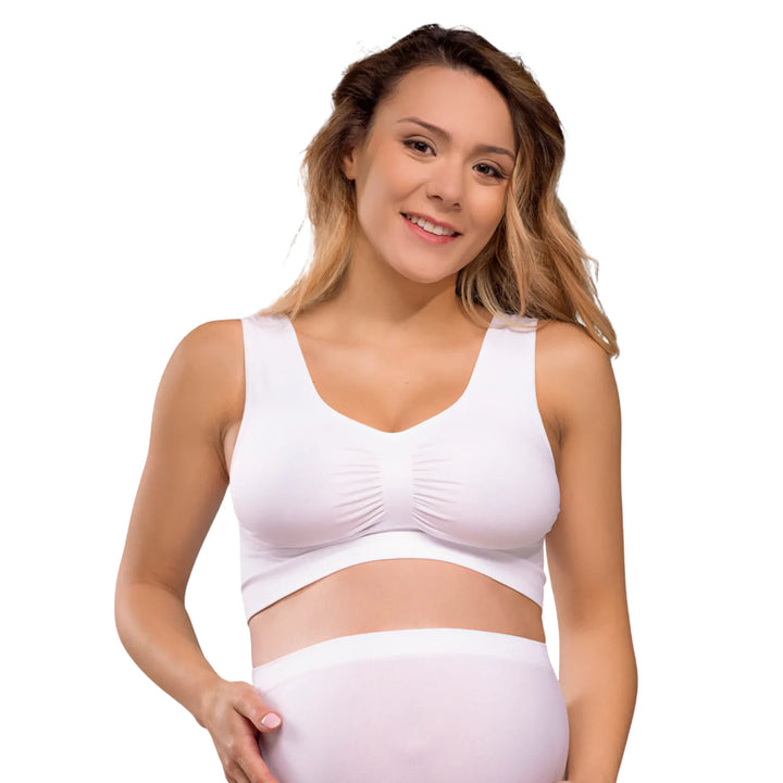 Woman wearing a white Carriwell seamless maternity bra, providing soft stretch support and everyday comfort throughout pregnancy.