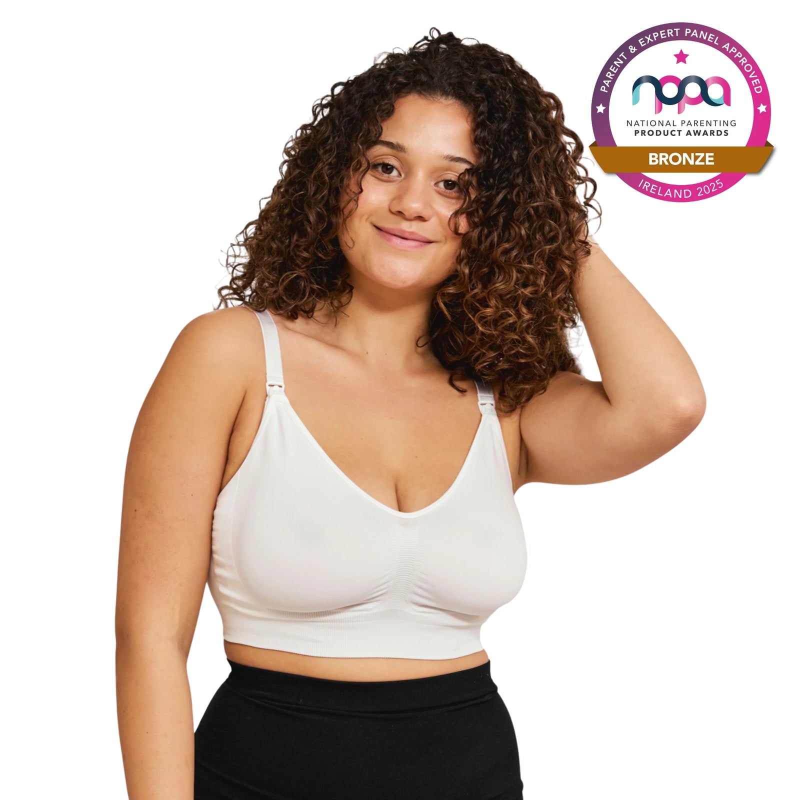 Woman wearing a white breastfeeding bra with a bronze NPPA badge on a white background