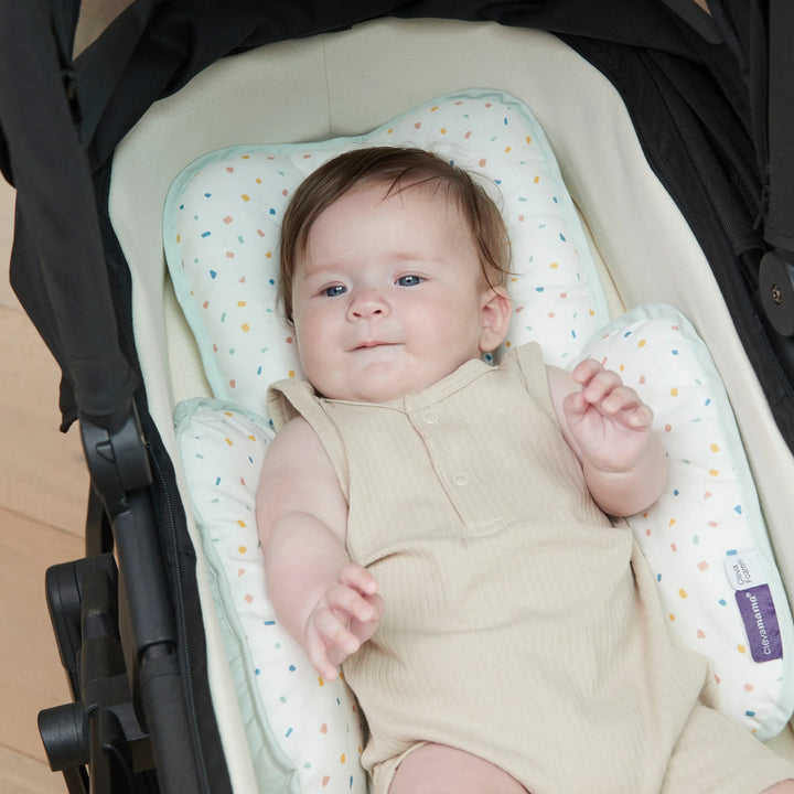 ClevaMama ClevaFoam Head and Neck Support Terrazzo design — baby lying comfortably in stroller with ergonomic ClevaFoam head and body cushion. Soft, breathable, and hypoallergenic newborn insert that helps prevent flat head syndrome and provides head and neck stability for use in car seats, bouncers, and pushchairs