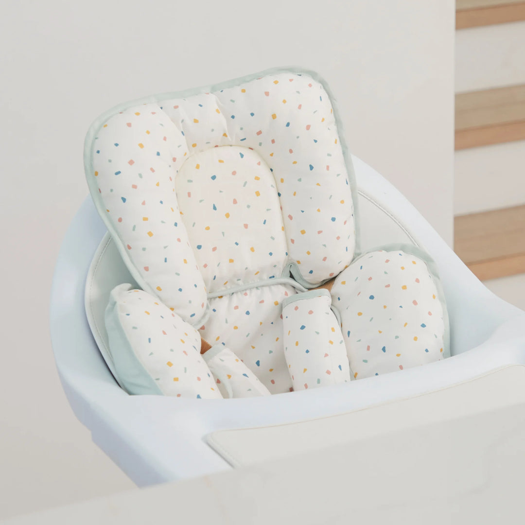 ClevaMama ClevaFoam Head and Neck Support Terrazzo design — baby head and body support cushion fitted in a modern high chair. Ergonomic newborn insert made with ClevaFoam technology to prevent flat head syndrome, offering breathable comfort and safe positioning for use in car seats, bouncers, and strollers