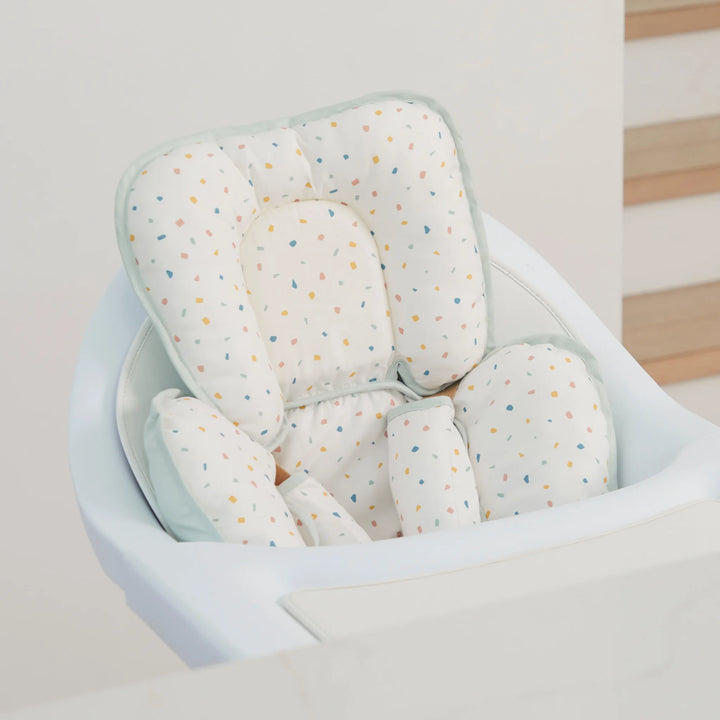 ClevaMama ClevaFoam Head and Neck Support Terrazzo design — baby head and body support cushion fitted in a modern high chair. Ergonomic newborn insert made with ClevaFoam technology to prevent flat head syndrome, offering breathable comfort and safe positioning for use in car seats, bouncers, and strollers