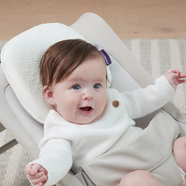 Baby sitting on ClevaMama ClevaFoam Infant Pillow – breathable and supportive memory foam baby pillow designed to prevent flat head syndrome, providing comfort and head support for infants aged 0–6 months.