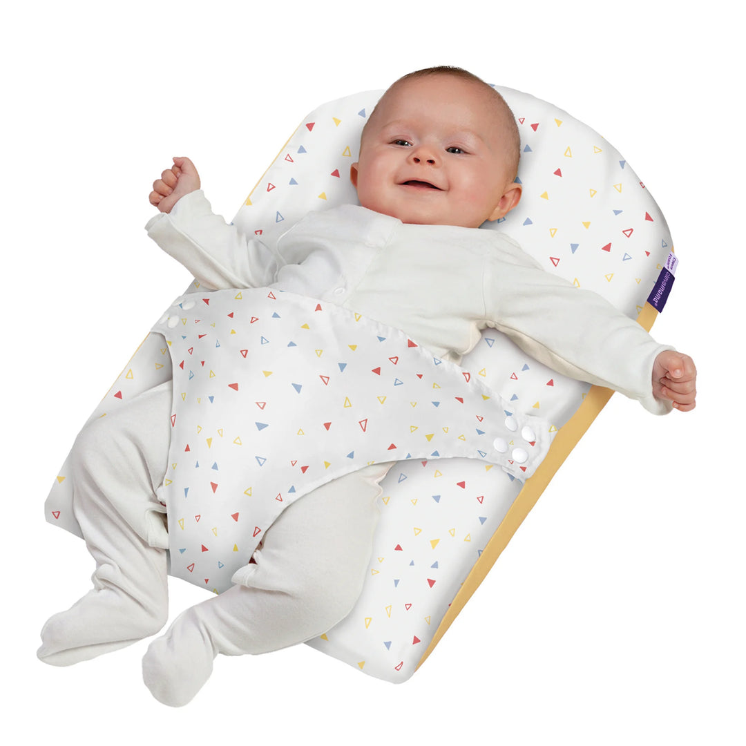 Smiling baby resting on ClevaMama ClevaFoam Reflux Wedge Elevated Support — breathable anti-reflux baby wedge designed to reduce reflux, congestion, and colic while keeping infants comfortably elevated for safe sleep and relaxation.