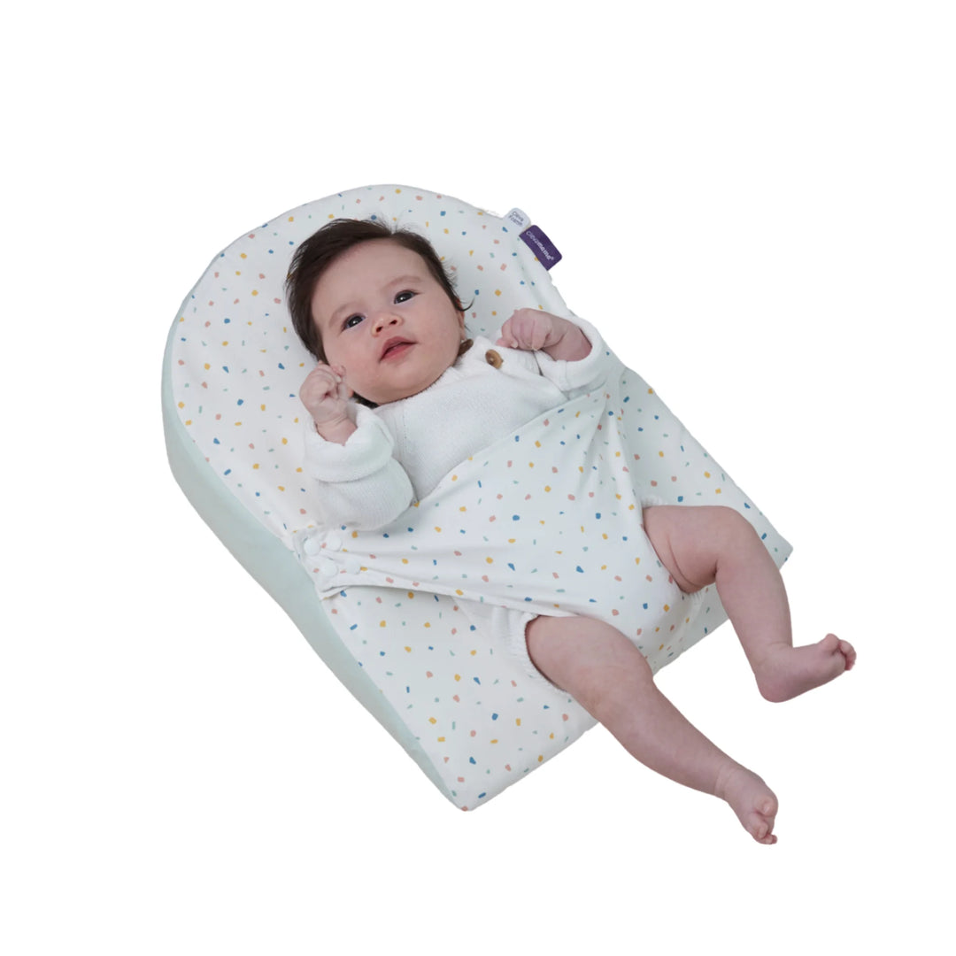 Baby lying comfortably on ClevaMama ClevaFoam Reflux Wedge Elevated Support in terrazzo design — breathable anti-reflux baby wedge providing gentle elevation to ease reflux, congestion, and colic while promoting safe, comfortable sleep.