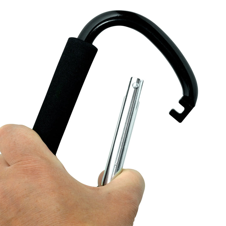 Hand opening a ClevaMama ClevaHooks stroller clip, showing the metal carabiner gate and foam grip on a white background.
