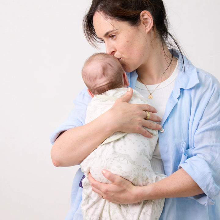 Mother holding baby in ClevaMama ClevaSleep Forest Friends swaddle sleeping bag, newborn sleep sack