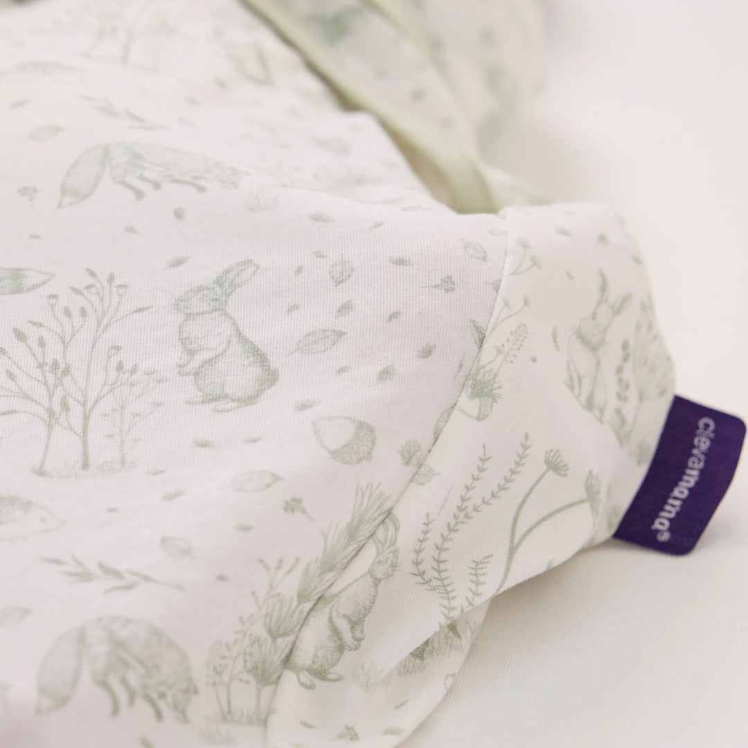 Close-up of ClevaMama ClevaSleep Forest Friends swaddle sleeping bag fabric and label, woodland print newborn sleep sack
