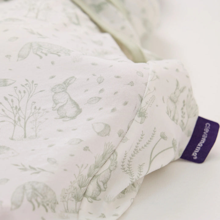 Close-up of ClevaMama ClevaSleep Forest Friends swaddle sleeping bag fabric and label, woodland print newborn sleep sack