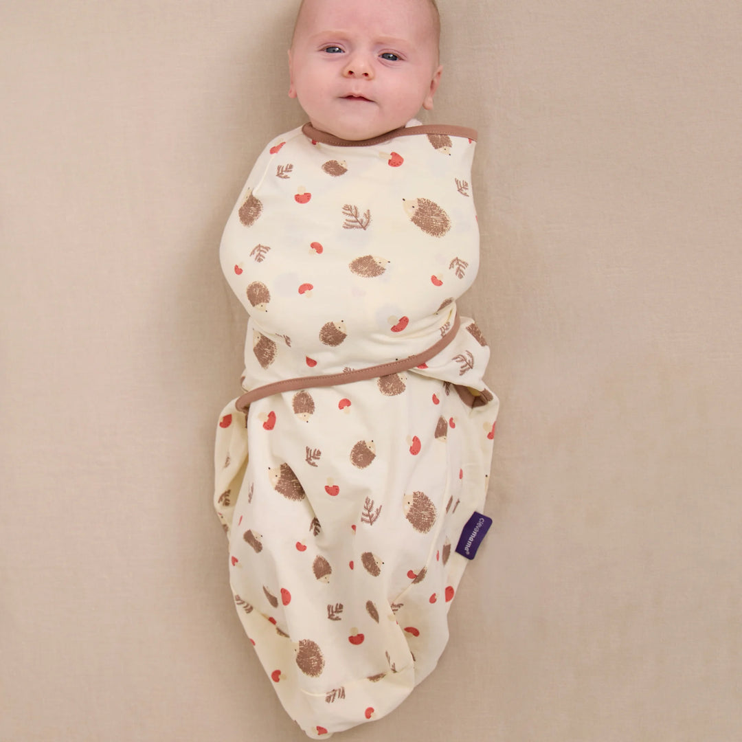 Baby wearing ClevaMama ClevaSleep swaddle sleeping bag in hedgehog woodland print, newborn sleep sack