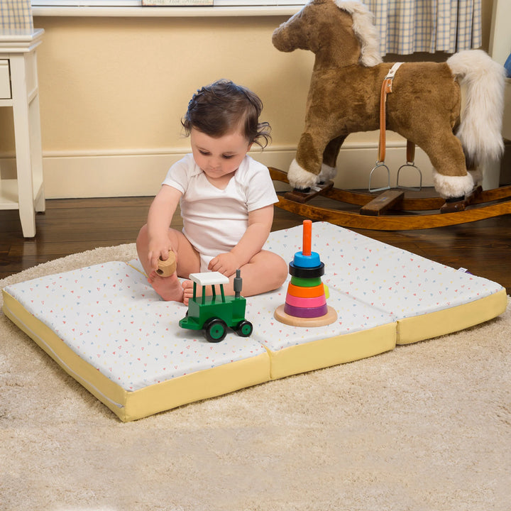 Child sitting on ClevaFoam Travel Mattress for use as a play mat in a playroom.