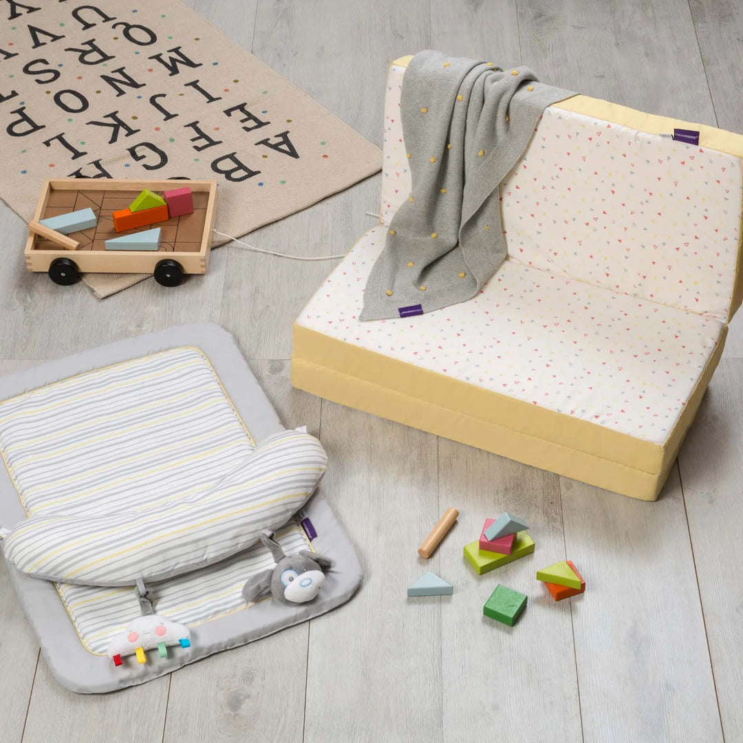 ClevaFoam Travel Cot Mattress in Seat Mode on wooden floor.