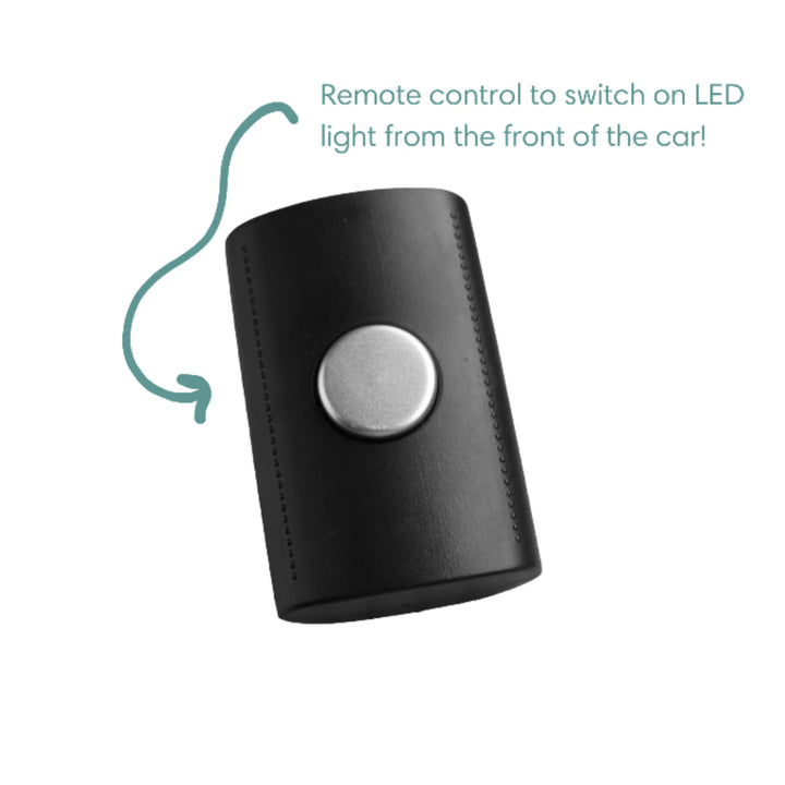 Battery-operated remote control for the EziMoov LED Pro baby car seat mirror, featuring a single large button to switch the LED light on from the front seat for safer rear-facing baby visibility.