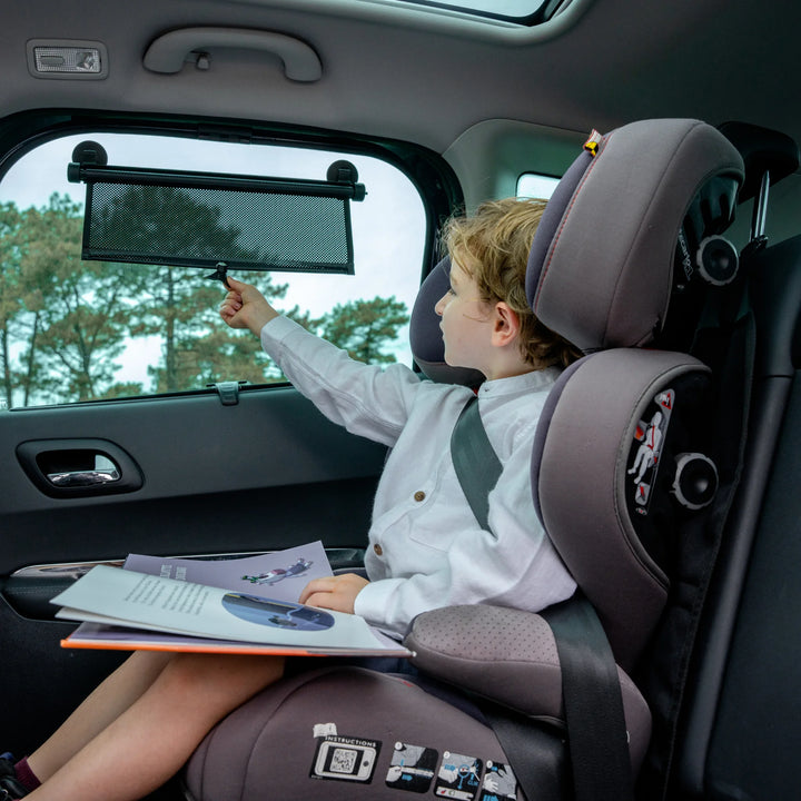 This image shows the retractable car window sun shield being pulled down for use by a child in their car seat.