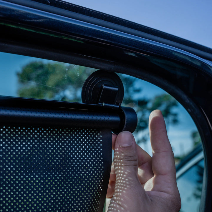 This image shows a parent retracting the sunshade with the button on the side.