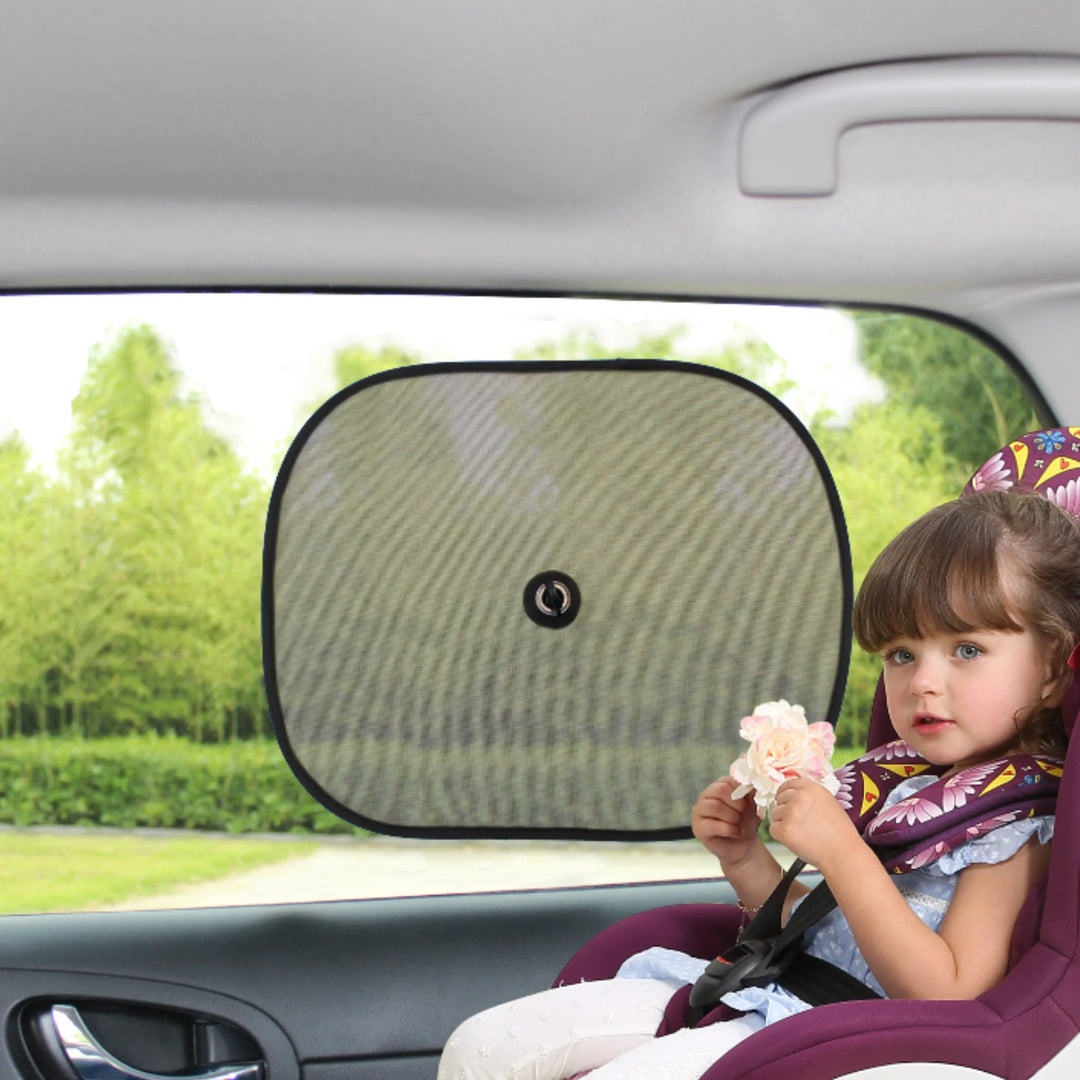 Toddler sitting safely in a car seat next to an EziMoov car sun shade with central suction cup, blocking bright sunlight and providing UV protection for children during car journeys.