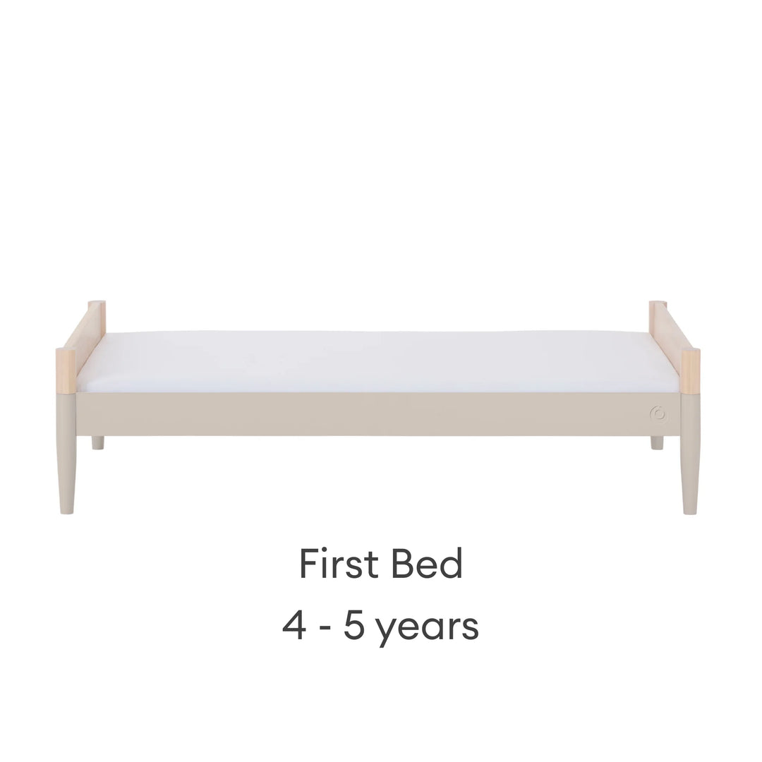 Gaia Baby Eos convertible cot in natural wood and cashmere finish configured as a first bed for 4–5 years on a white background.