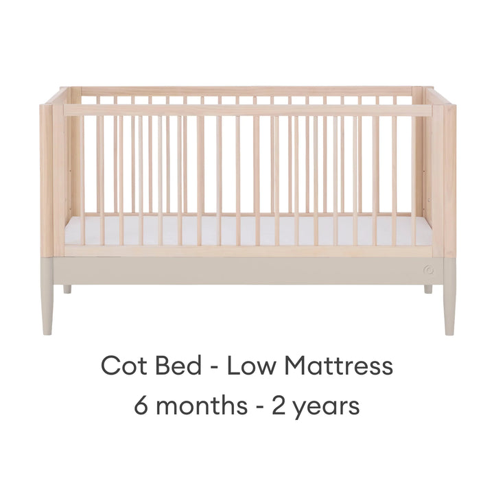 Gaia Baby Eos convertible cot in natural wood and cashmere finish with mattress in low position for 6 months to 2 years on a white background.