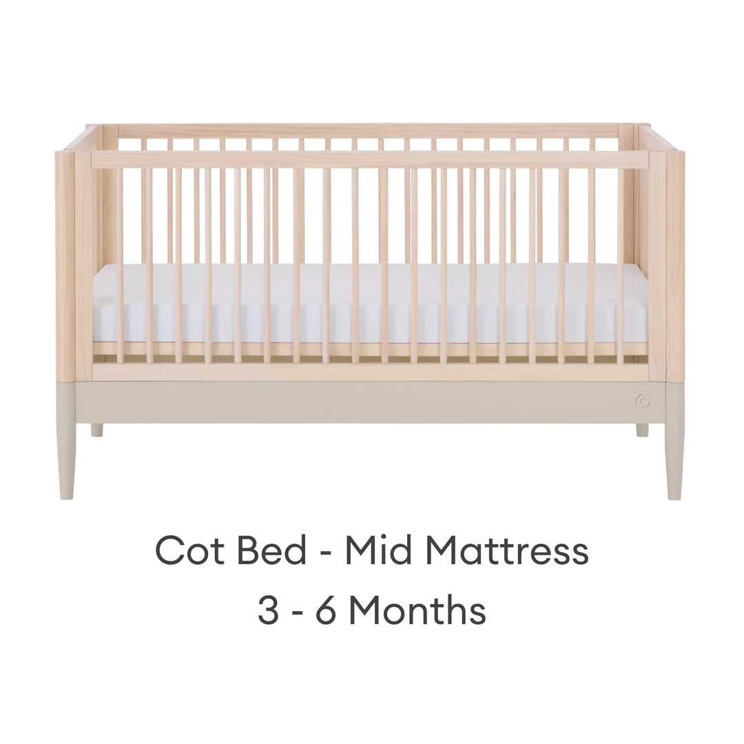 Gaia Baby Eos convertible cot in natural wood and cashmere finish with mattress in mid position for 3–6 months on a white background.