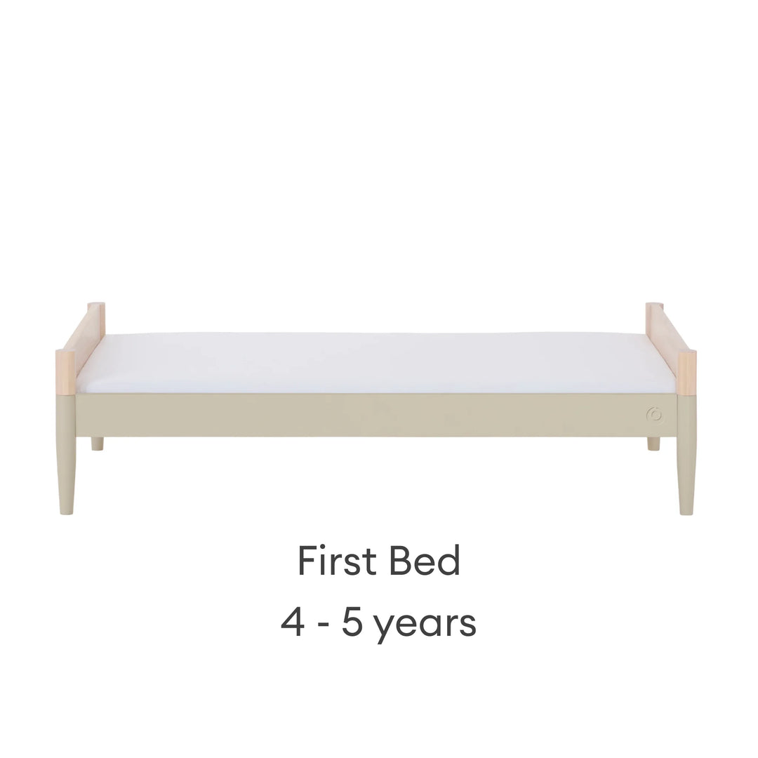 Gaia Baby Eos convertible cot transformed into first bed for ages 4–5 years in natural desert sage finish on a white background.