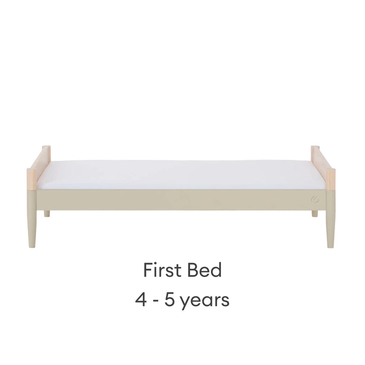 Gaia Baby Eos convertible cot transformed into first bed for ages 4–5 years in natural desert sage finish on a white background.